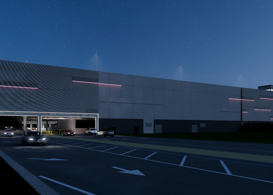 Parking Garage Exterior At Night With Illuminated Facade And Drive Aisles