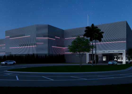 Parking Garage Exterior At Night With Entrance Drive And Lighting